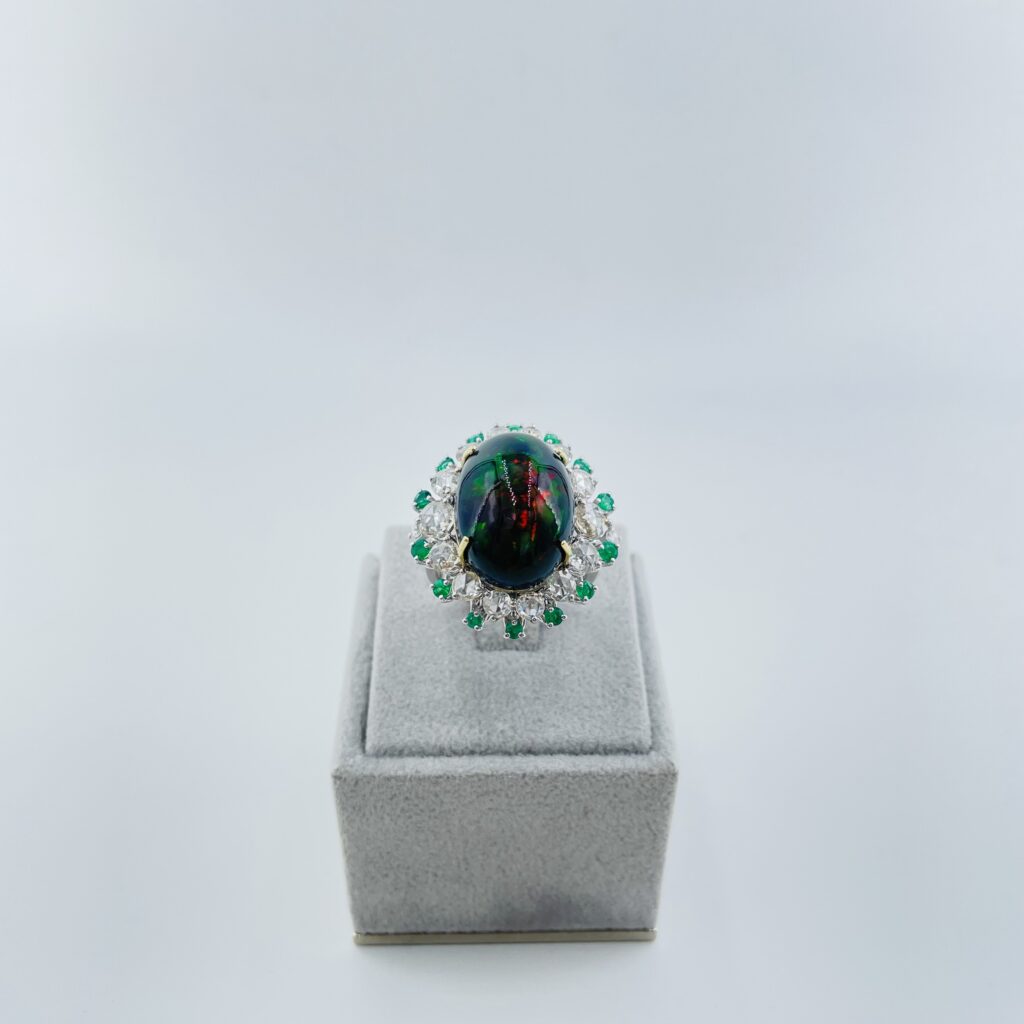 anello in oro bianco con opale, smeraldi e diamanti